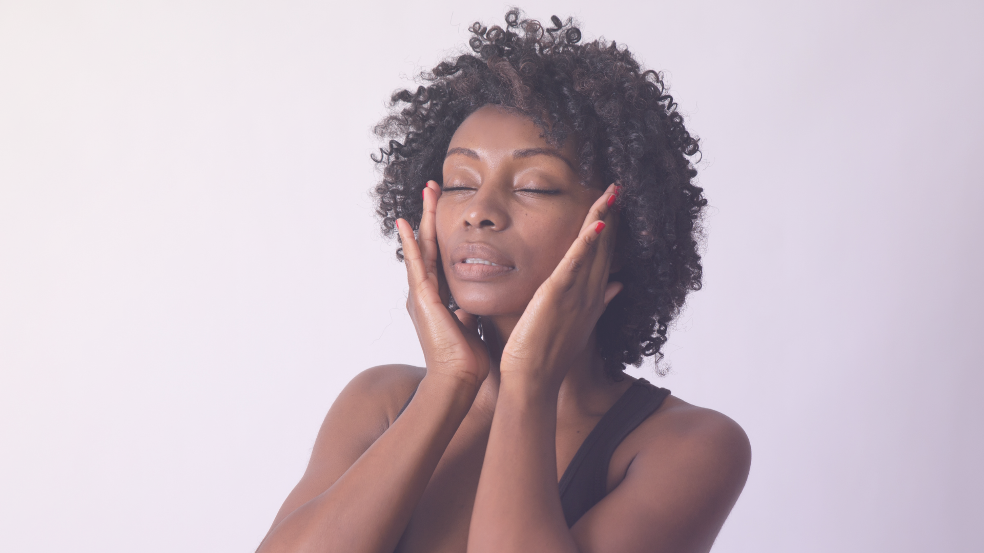 Woman with her eyes closed, with her hands raised touching her temples