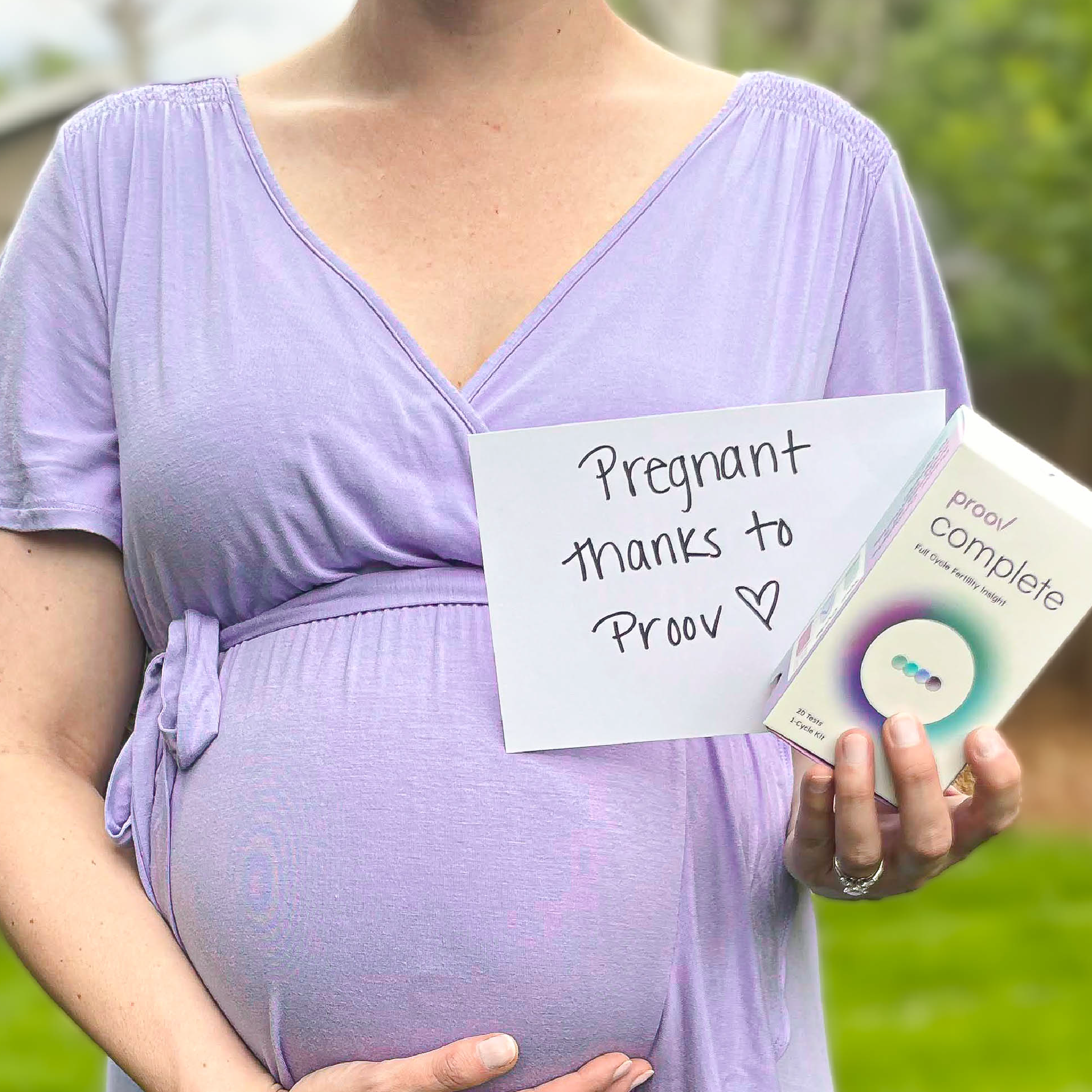 Pregnanct woman holding Proov Complete and a sign saying "Pregnant thanks to Proov."