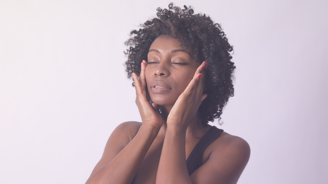 Woman with her eyes closed, with her hands raised touching her temples